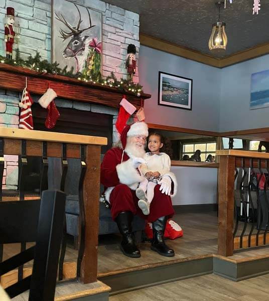 Santa with child by fireplace