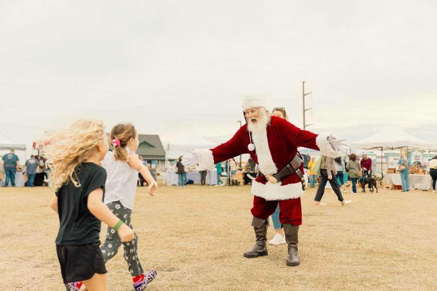 Santa greeting kids on beach