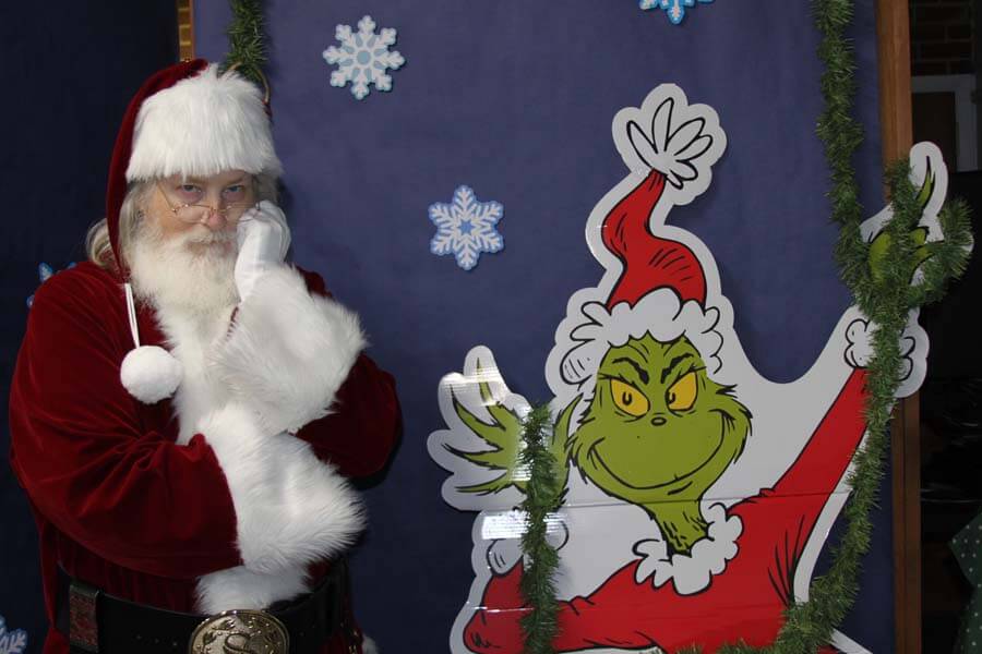 Santa next to Grinch decoration